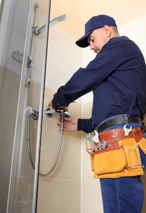 Technician unclogging shower drain in Scottsdale home